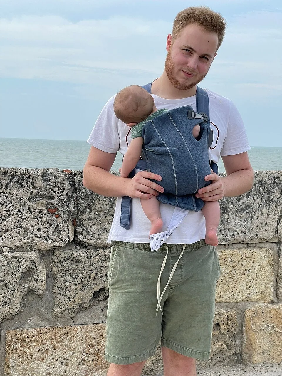 Un adulte portant un enfant : photographie d’usage, sans identification du porte-bébé Tula.